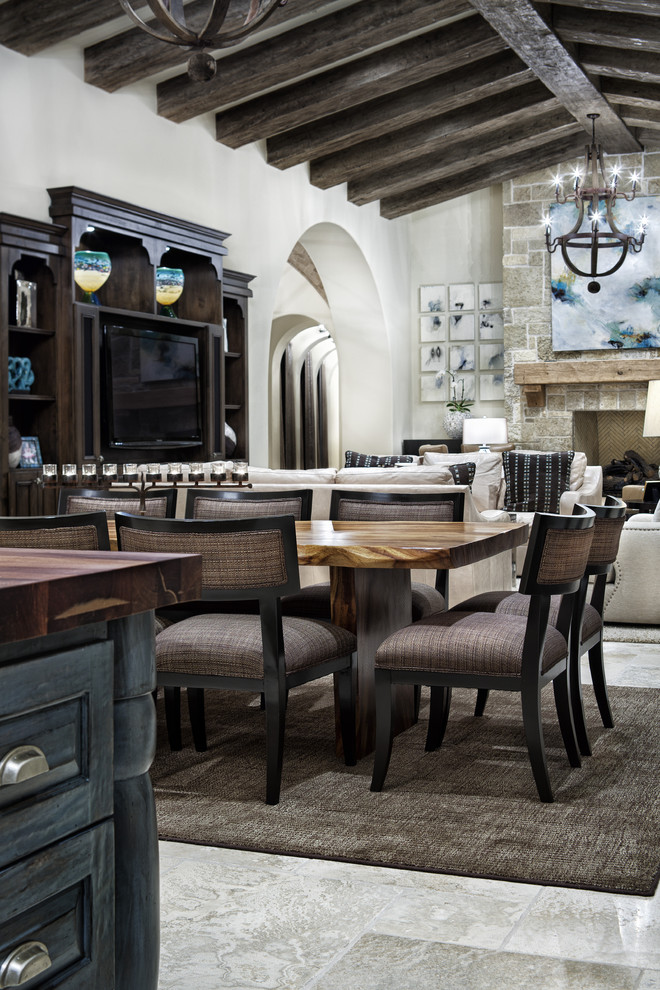 Photo of a mediterranean dining room in Austin with a stone fireplace surround.