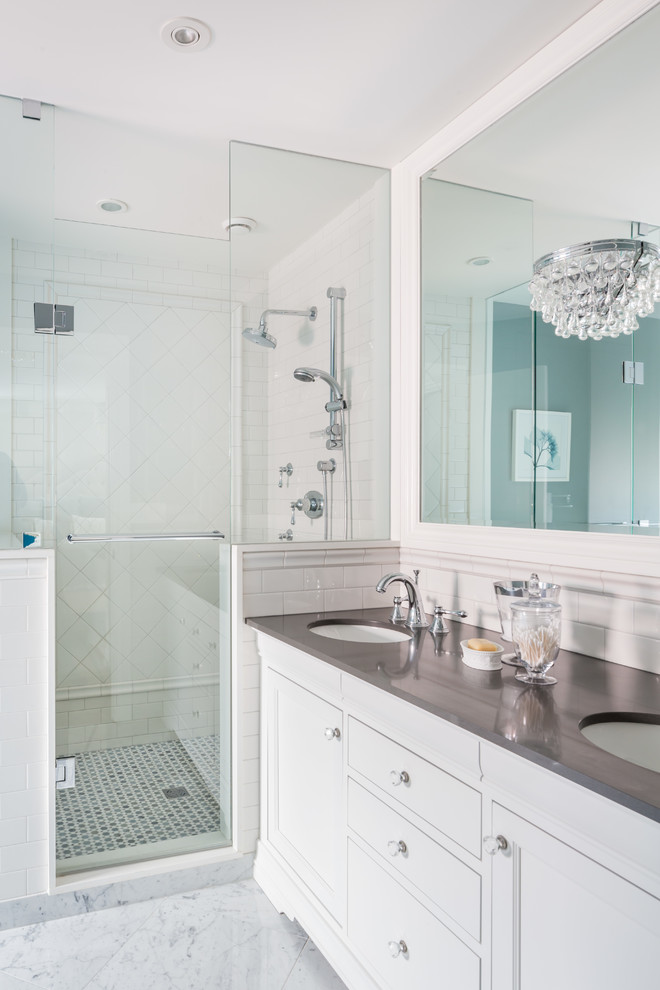 This is an example of a mid-sized transitional master bathroom in Toronto with a drop-in sink, raised-panel cabinets, white cabinets, solid surface benchtops, a corner shower, white tile, ceramic tile, white walls and marble floors.