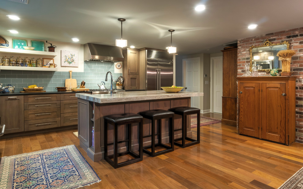 Large arts and crafts l-shaped eat-in kitchen in Boston with an integrated sink, recessed-panel cabinets, grey cabinets, granite benchtops, blue splashback, ceramic splashback, stainless steel appliances, light hardwood floors, with island and brown floor.