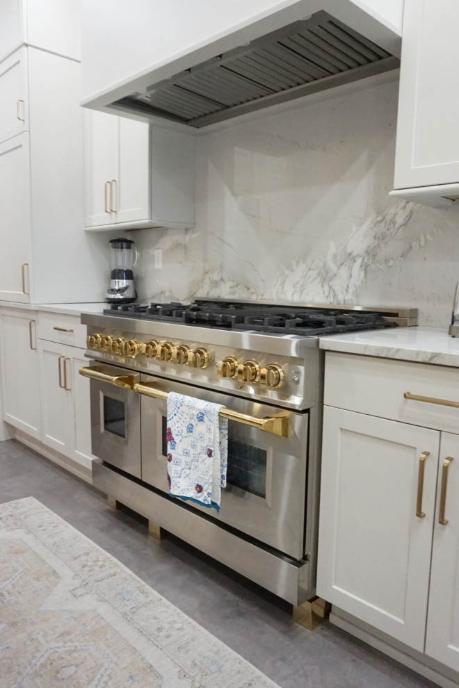 Inspiration for a transitional vinyl floor and gray floor kitchen remodel with an undermount sink, shaker cabinets, gray cabinets, quartzite countertops, stone slab backsplash, stainless steel appliances and an island