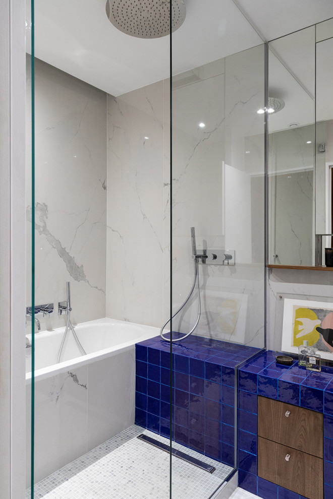 Пример оригинального дизайна: ванная комната в современном стиле с плоскими фасадами, фасадами цвета дерева среднего тона, ванной в нише, душевой комнатой, белой плиткой, полом из мозаичной плитки, белым полом, душем с распашными дверями, синей столешницей и встроенной тумбой