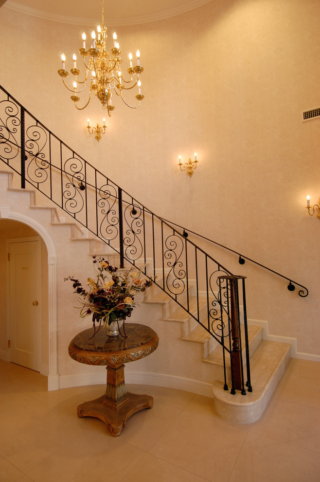 Photo of a traditional marble curved staircase in Yokohama with marble risers, metal railing and wallpaper.