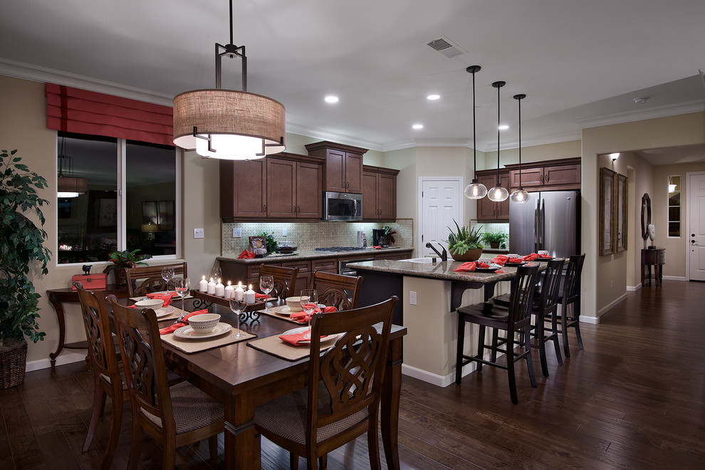 Inspiration for a transitional dark wood floor and brown floor kitchen remodel with dark wood cabinets, granite countertops, gray backsplash, ceramic backsplash, stainless steel appliances and an island