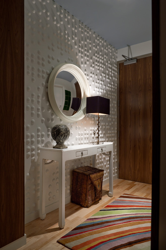 This is an example of an eclectic entryway in New York with white walls and laminate floors.