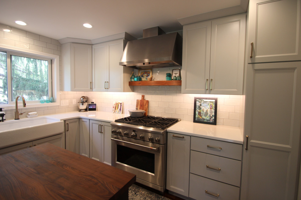 Bild på ett eklektiskt flerfärgad flerfärgat kök, med en rustik diskho, skåp i shakerstil, grå skåp, bänkskiva i kvartsit, vitt stänkskydd, stänkskydd i tunnelbanekakel, rostfria vitvaror och en köksö