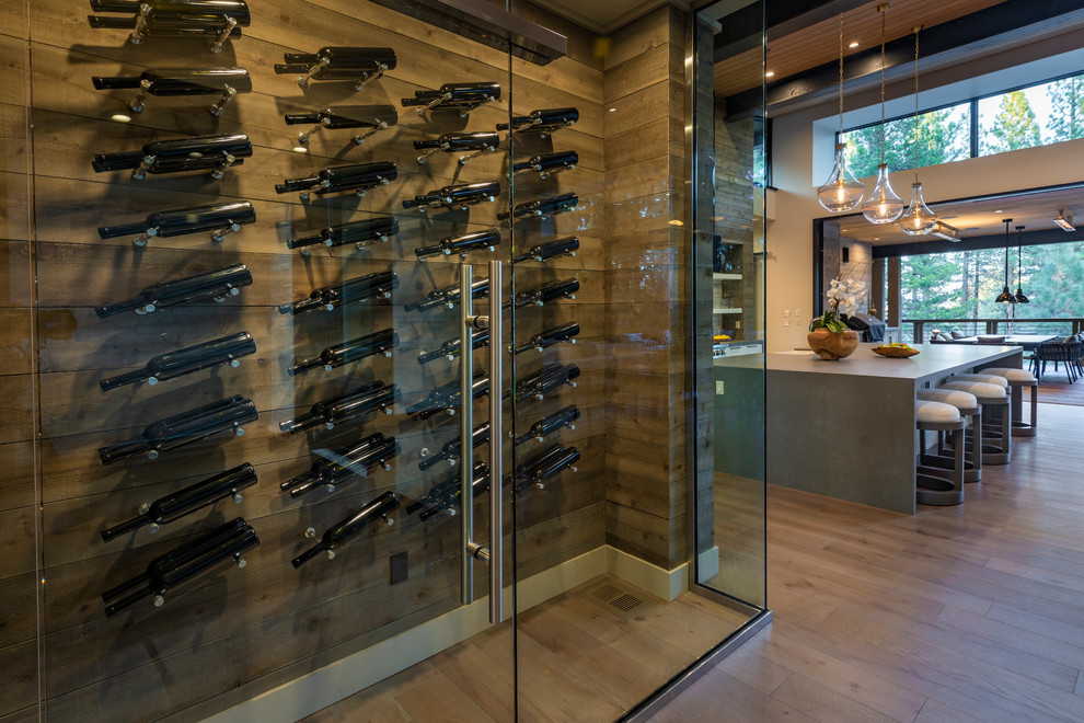 This is an example of a large modern wine cellar in Other with display racks, light hardwood floors and beige floor.