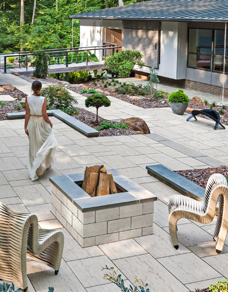 На фото: двор на заднем дворе в стиле модернизм с местом для костра и мощением тротуарной плиткой с