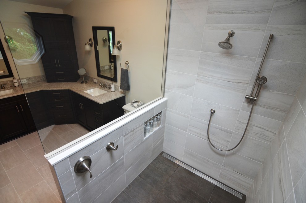 Design ideas for a mid-sized transitional master bathroom in Other with recessed-panel cabinets, dark wood cabinets, an open shower, a two-piece toilet, gray tile, porcelain tile, grey walls, porcelain floors, an undermount sink and engineered quartz benchtops.