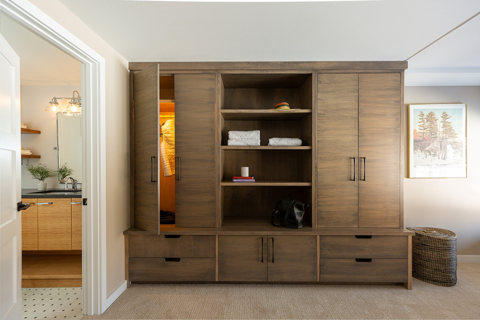 Ejemplo de armario y vestidor unisex actual pequeño con a medida, armarios con paneles lisos, puertas de armario de madera oscura, moqueta y suelo beige