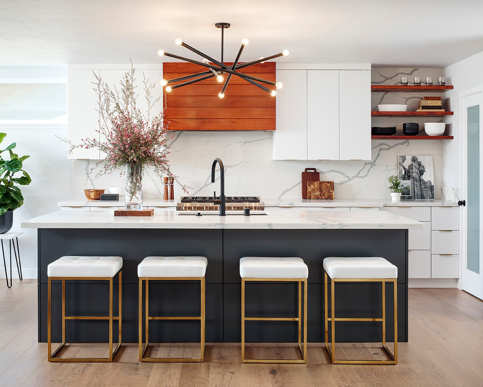 Design ideas for a large contemporary galley kitchen in San Diego with an undermount sink, flat-panel cabinets, white cabinets, marble benchtops, white splashback, marble splashback, stainless steel appliances, light hardwood floors, with island, beige floor and white benchtop.