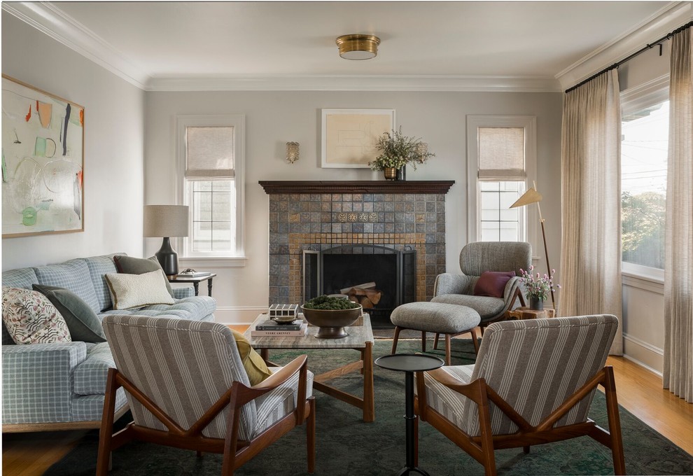 Design ideas for a traditional living room in Seattle with grey walls, medium hardwood floors, a standard fireplace, a tile fireplace surround and brown floor.
