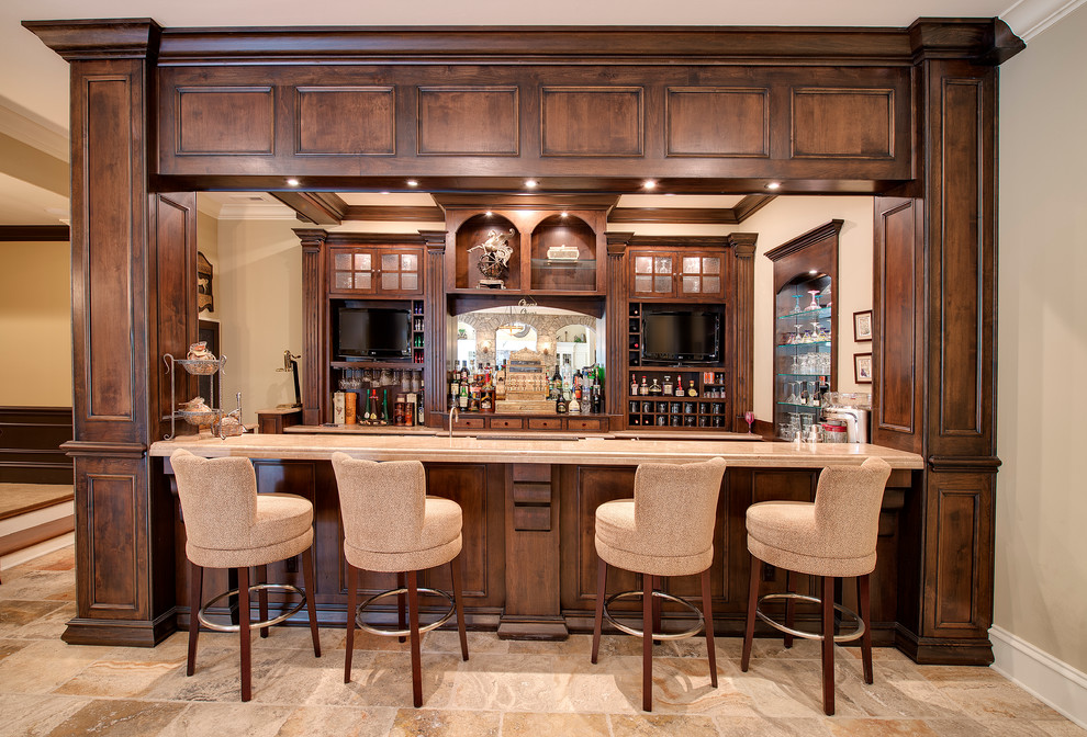 Photo of a mid-sized traditional galley wet bar in Indianapolis with limestone floors, glass-front cabinets and dark wood cabinets.