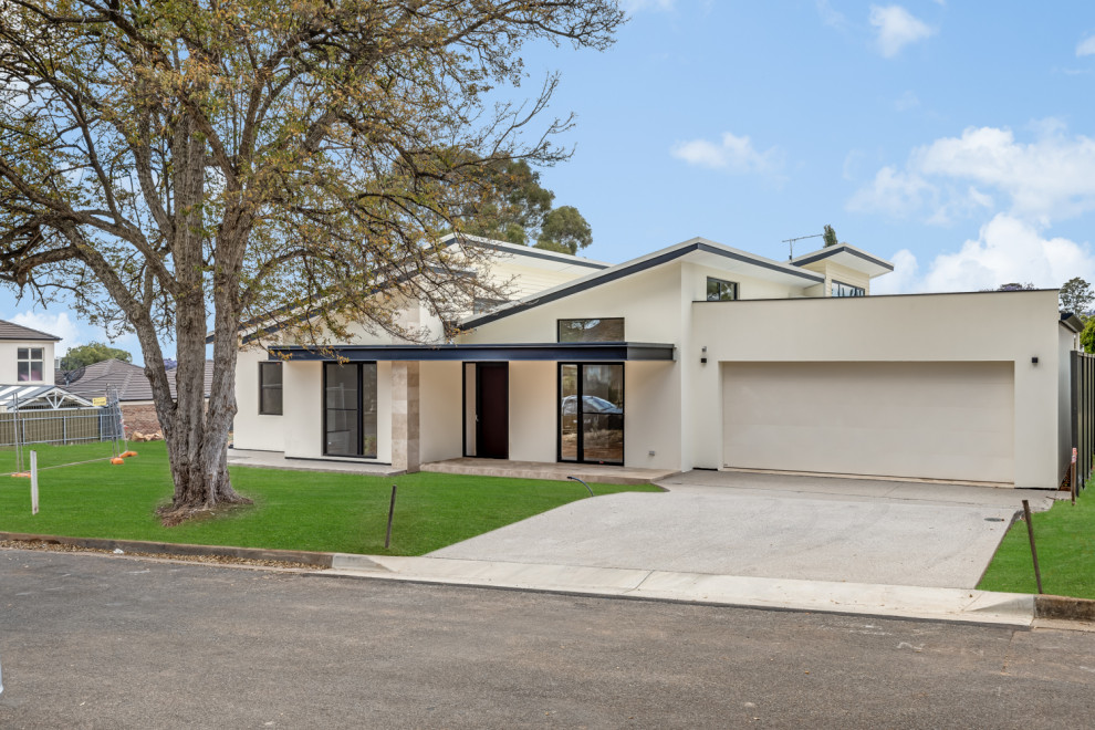 Großes, Einstöckiges Modernes Einfamilienhaus mit Betonfassade, beiger Fassadenfarbe, Schmetterlingsdach, Blechdach, weißem Dach und Verschalung in Adelaide