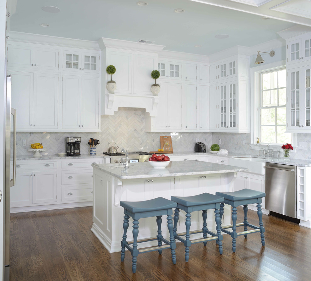 Traditional kitchen in Charleston with a farmhouse sink, shaker cabinets, white cabinets, grey splashback, with island and dark hardwood floors.