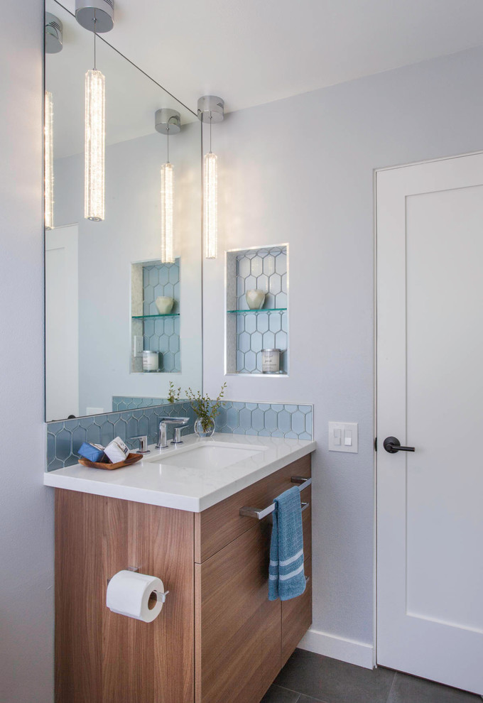 Design ideas for a mid-sized transitional kids bathroom in San Diego with shaker cabinets, brown cabinets, an alcove tub, a shower/bathtub combo, a two-piece toilet, blue tile, glass tile, red walls, porcelain floors, an undermount sink, engineered quartz benchtops, grey floor, a shower curtain and white benchtops.
