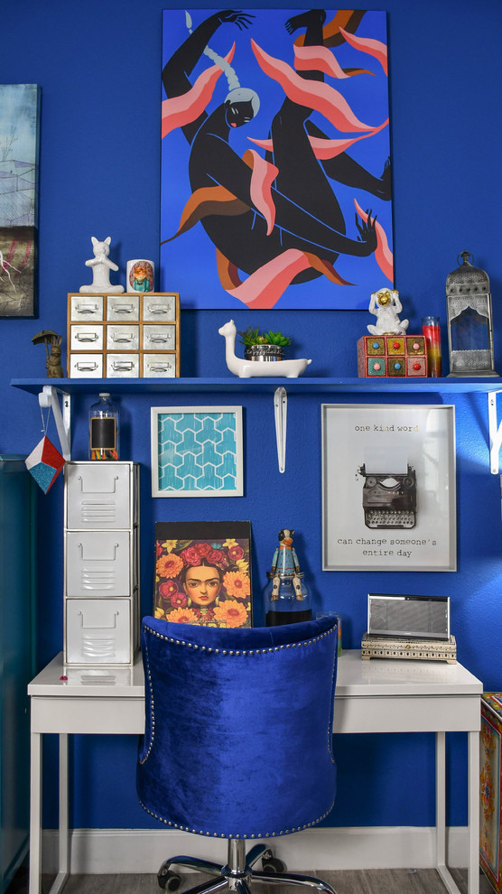 This is an example of a large eclectic home office in Orlando with blue walls, a freestanding desk and grey floor.