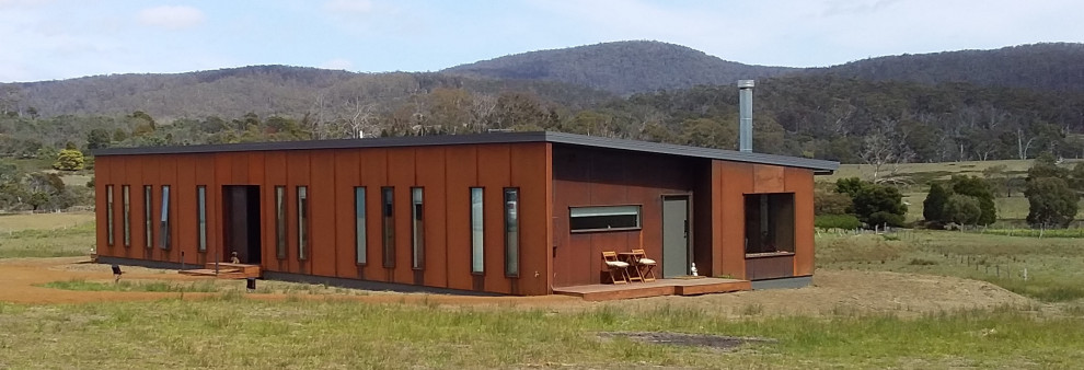 Mid-sized contemporary brown one-story metal house exterior idea in Hobart with a shed roof, a metal roof and a gray roof