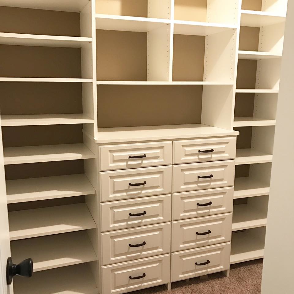 Inspiration for a mid-sized traditional gender-neutral walk-in wardrobe in Houston with raised-panel cabinets, white cabinets and carpet.