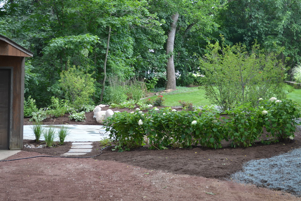 Mid-sized country backyard garden in Milwaukee with natural stone pavers.