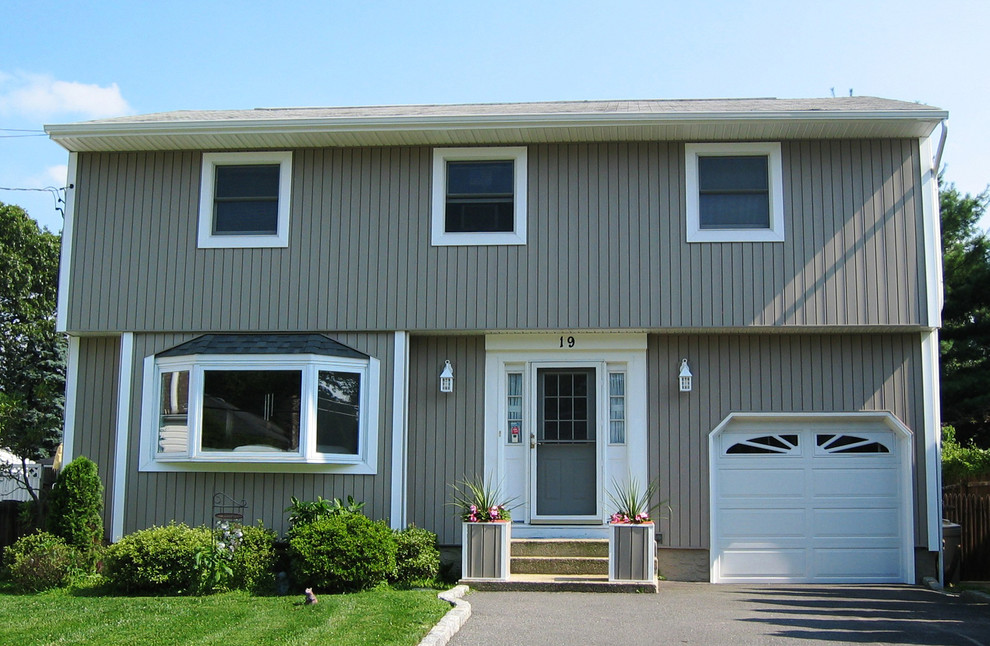 Inspiration for a mid-sized contemporary two-storey grey exterior in Huntington with vinyl siding and a gable roof.