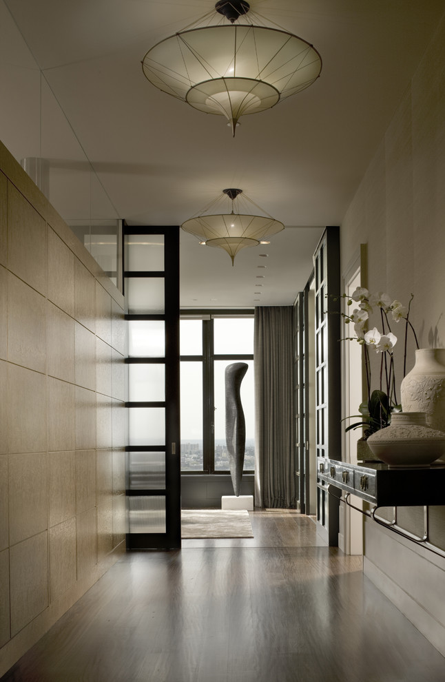 Photo of a mid-sized transitional hallway in New York with beige walls and medium hardwood floors.
