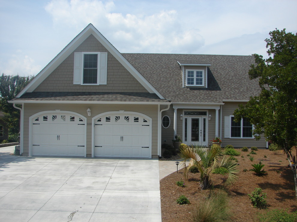 Photo of a mid-sized traditional two-storey beige exterior in Other with vinyl siding.