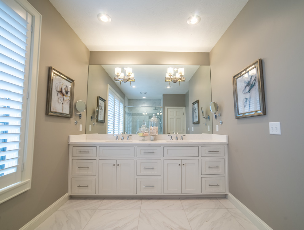 Inspiration for a large transitional master marble floor alcove shower remodel with shaker cabinets, white cabinets, beige walls, an undermount sink and quartz countertops