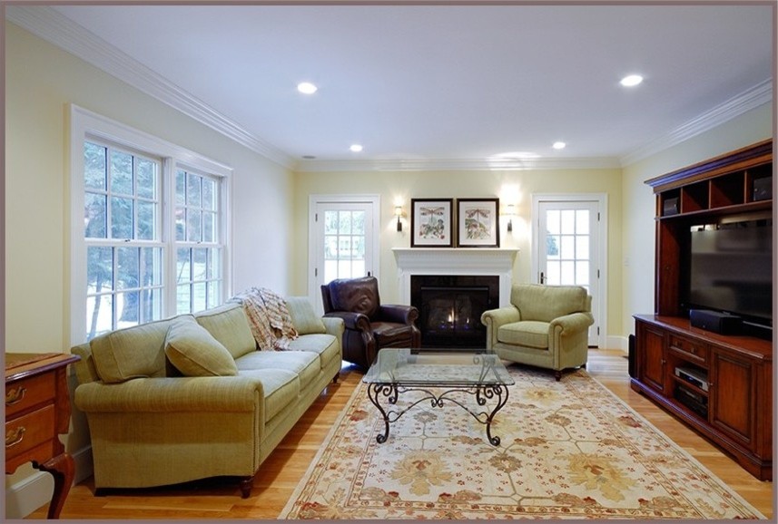 This is an example of a mid-sized arts and crafts open concept family room in Boston with beige walls, light hardwood floors, a standard fireplace, a wood fireplace surround, a built-in media wall and beige floor.