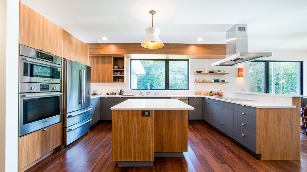Inspiration for a contemporary eat-in kitchen in Seattle with an undermount sink, flat-panel cabinets, quartz benchtops, white splashback, stainless steel appliances, bamboo floors, with island and white benchtop.