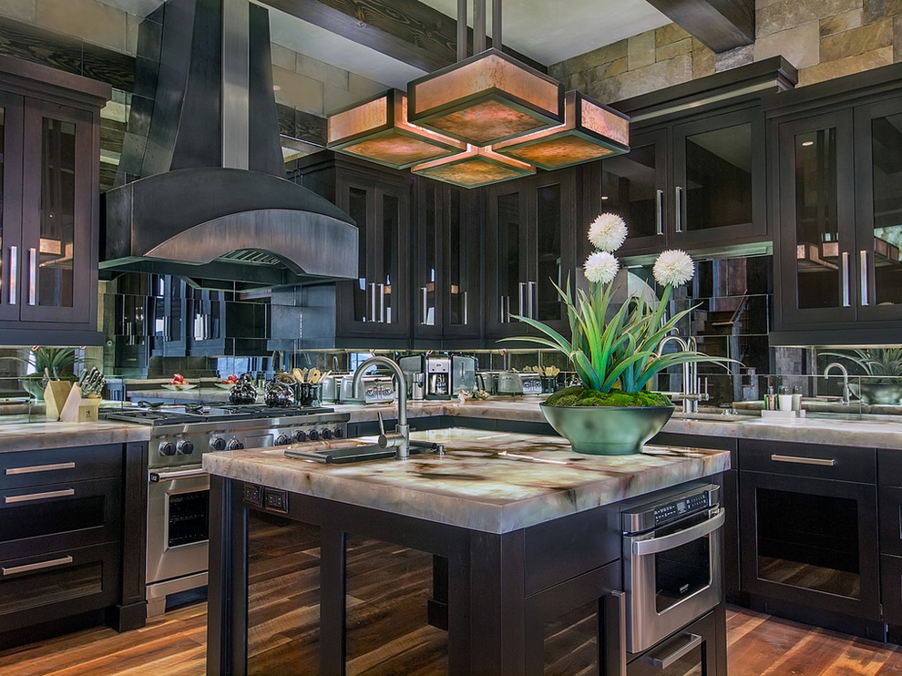 Example of a large mountain style u-shaped dark wood floor and brown floor kitchen design with a drop-in sink, shaker cabinets, dark wood cabinets, quartzite countertops, metallic backsplash, mirror backsplash, paneled appliances and two islands