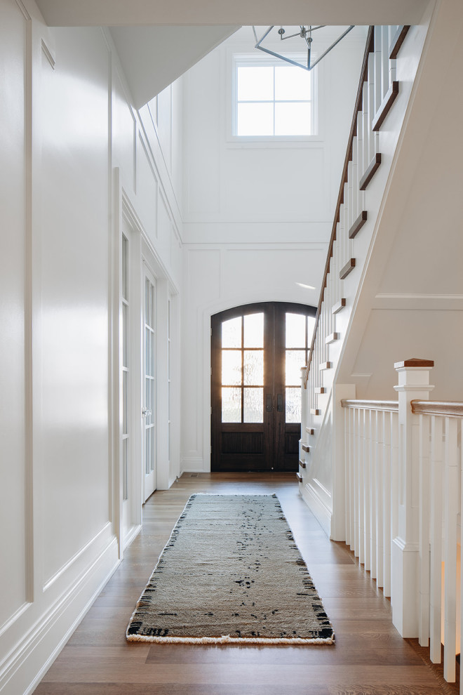 Источник вдохновения для домашнего уюта: большой коридор в стиле неоклассика (современная классика) с белыми стенами, светлым паркетным полом, коричневым полом и панелями на стенах
