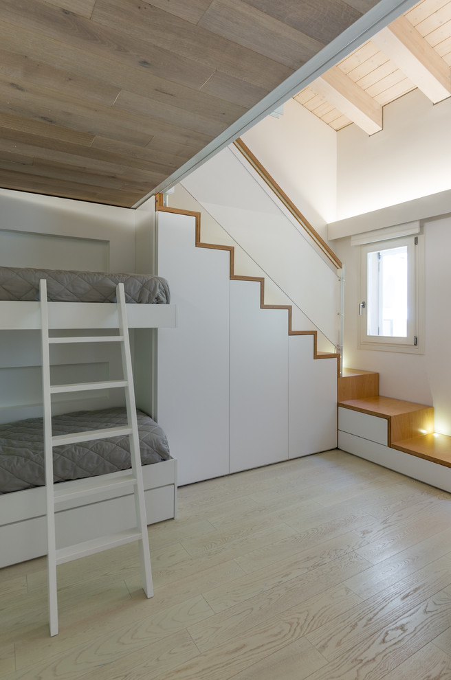Mid-sized modern guest bedroom in Other with white walls, light hardwood floors and yellow floor.