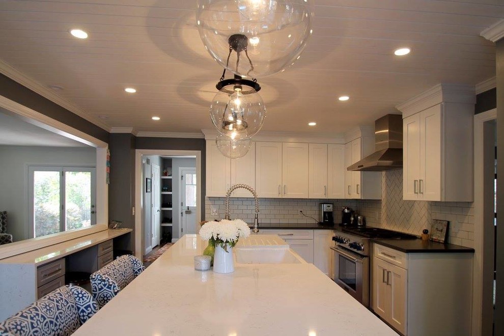 Eat-in kitchen - large transitional u-shaped dark wood floor eat-in kitchen idea in Denver with a farmhouse sink, shaker cabinets, gray cabinets, quartzite countertops, white backsplash, ceramic backsplash, stainless steel appliances and an island