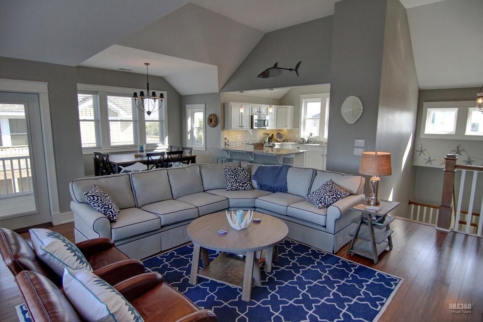 Inspiration for a mid-sized beach style formal open concept living room in Other with beige walls, medium hardwood floors, a standard fireplace, a tile fireplace surround and a wall-mounted tv.