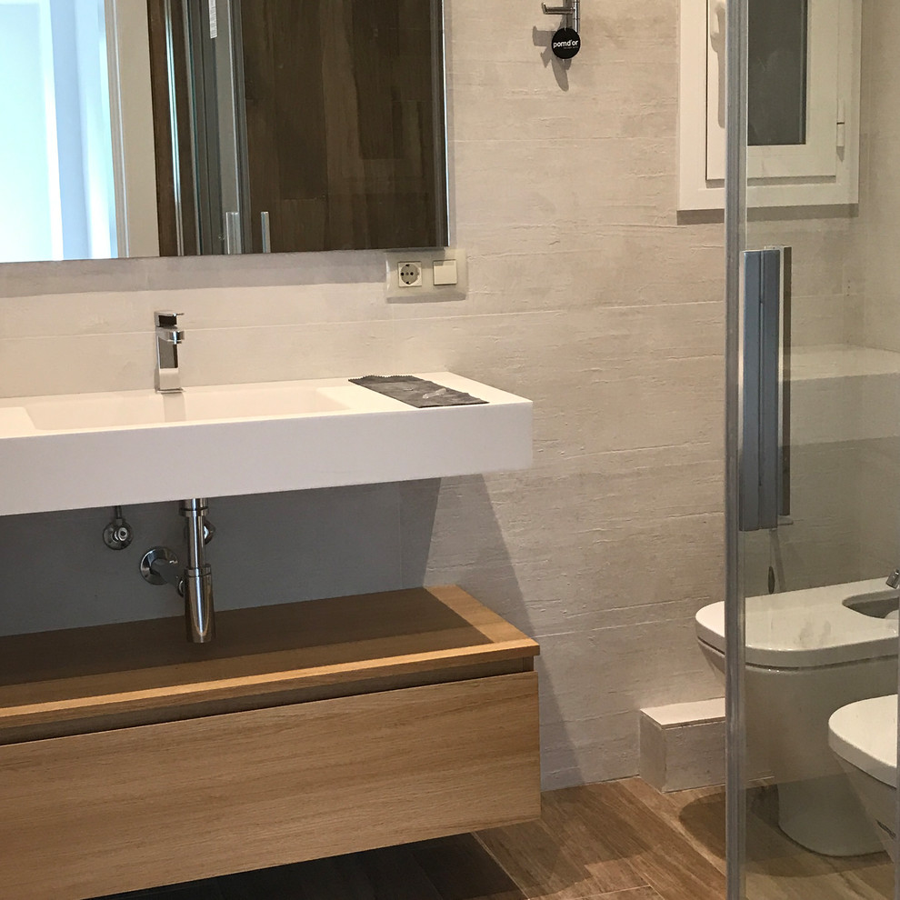 Mid-sized modern wet room bathroom in Barcelona with medium wood cabinets, a two-piece toilet, beige tile, porcelain tile, white walls, porcelain floors, a wall-mount sink, quartzite benchtops, multi-coloured floor and a sliding shower screen.