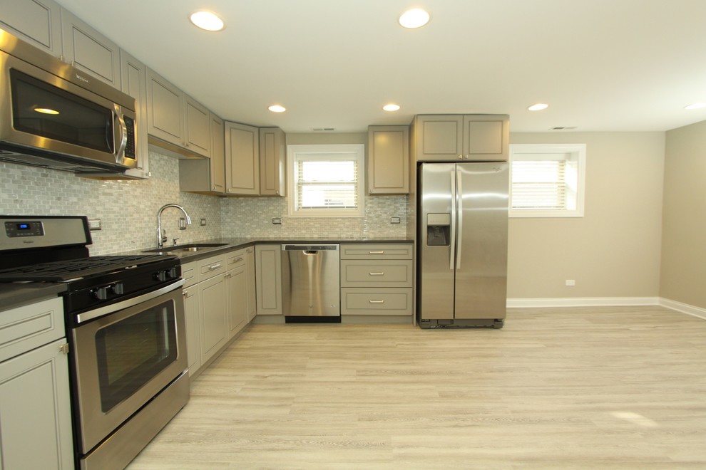 Kitchen - small transitional l-shaped porcelain tile and gray floor kitchen idea in Chicago with an undermount sink, beaded inset cabinets, gray cabinets, quartz countertops, white backsplash, mosaic tile backsplash, stainless steel appliances, no island and gray countertops