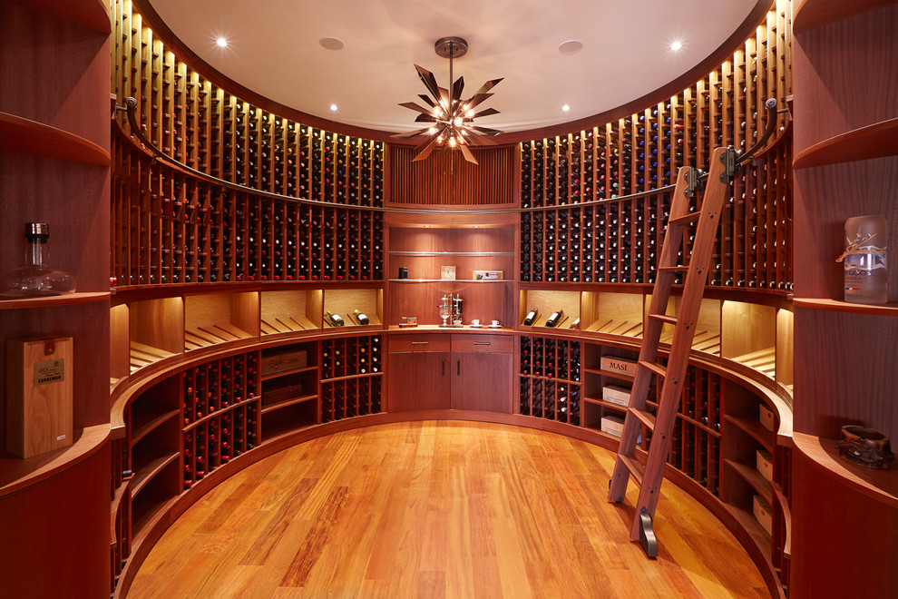 Traditional wine cellar in New York with medium hardwood floors, storage racks and orange floor.