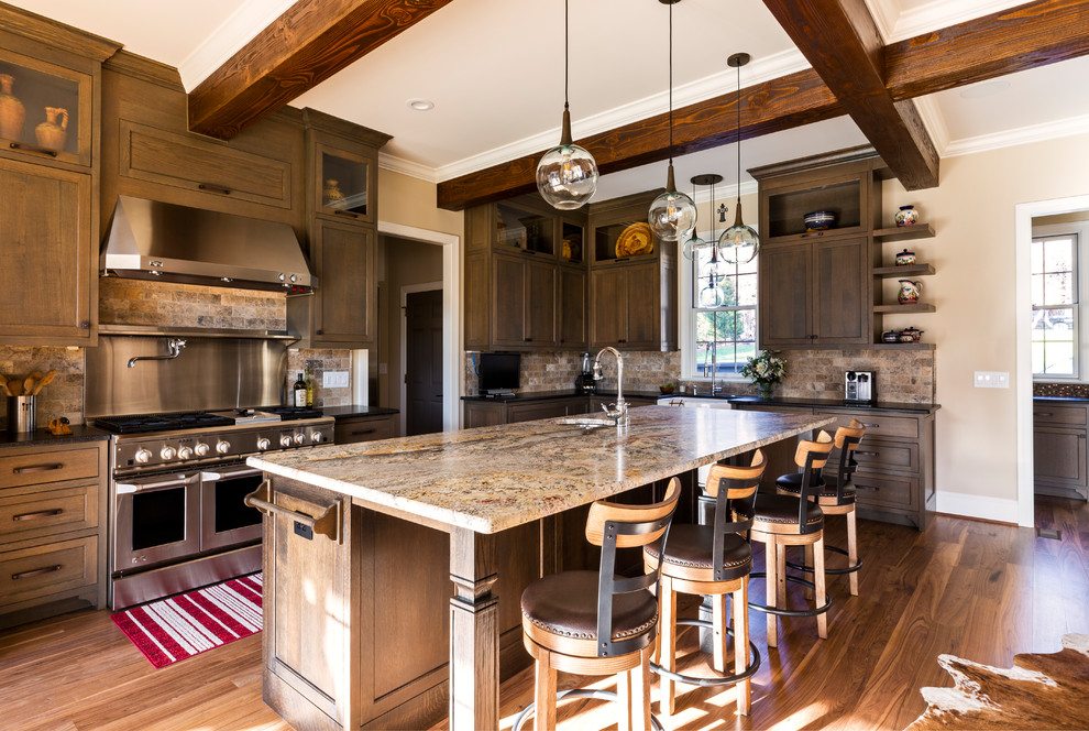 Expansive country l-shaped eat-in kitchen in Charlotte with a farmhouse sink, marble benchtops, ceramic splashback, stainless steel appliances, medium hardwood floors, with island, multi-coloured benchtop, shaker cabinets, dark wood cabinets, brown splashback and brown floor.