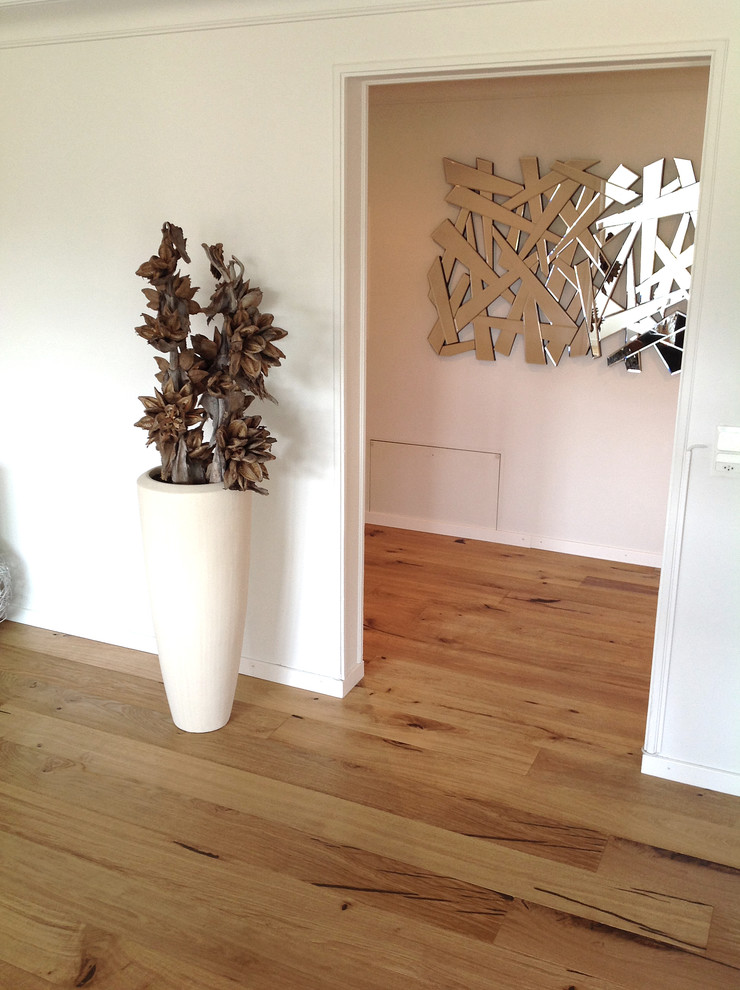 Inspiration for a mid-sized rustic medium tone wood floor hallway remodel with white walls