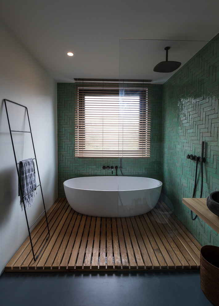Scandinavian wet room bathroom in Amsterdam with a freestanding tub, green tile, ceramic tile, white walls, medium hardwood floors, a vessel sink, wood benchtops, brown floor, an open shower and brown benchtops.