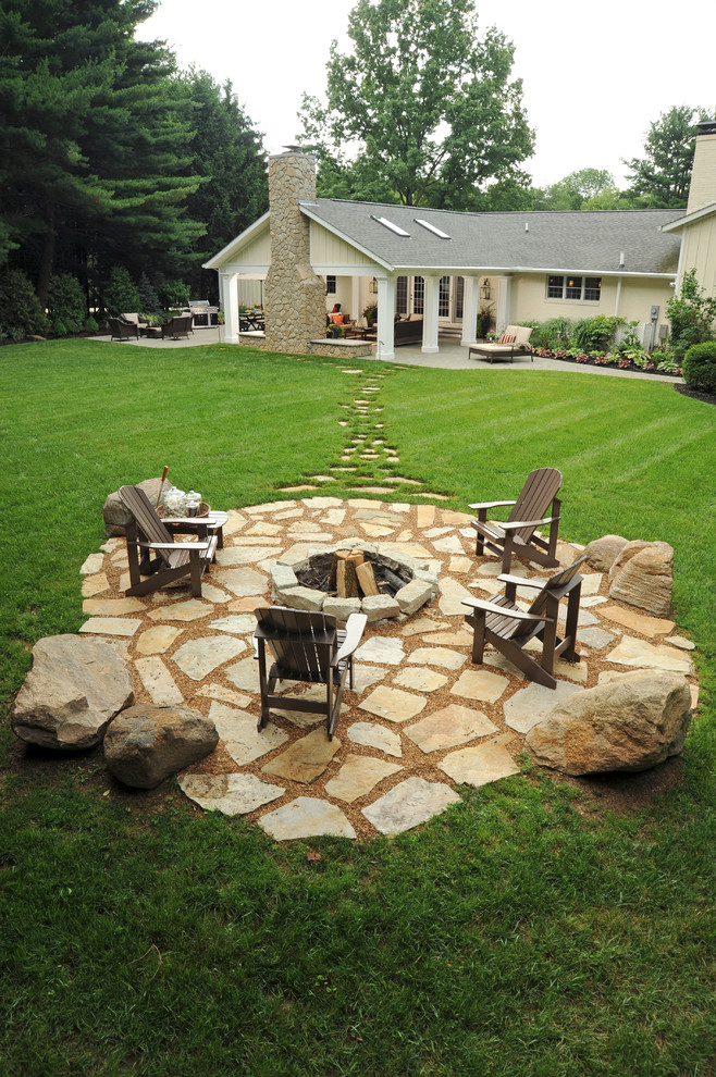 Design ideas for a large traditional backyard patio in Columbus with natural stone pavers and a fire feature.