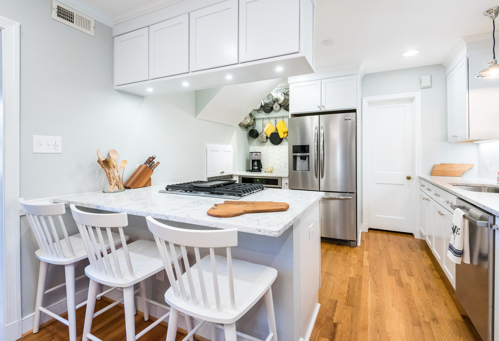 Kitchen - transitional medium tone wood floor kitchen idea in Richmond with a single-bowl sink, shaker cabinets, white cabinets, quartzite countertops, stainless steel appliances, a peninsula, white backsplash and mosaic tile backsplash