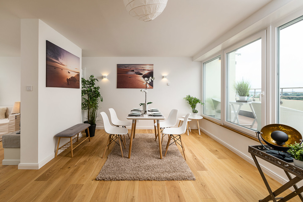 Design ideas for a mid-sized scandinavian open plan dining in Munich with white walls, medium hardwood floors, no fireplace and brown floor.