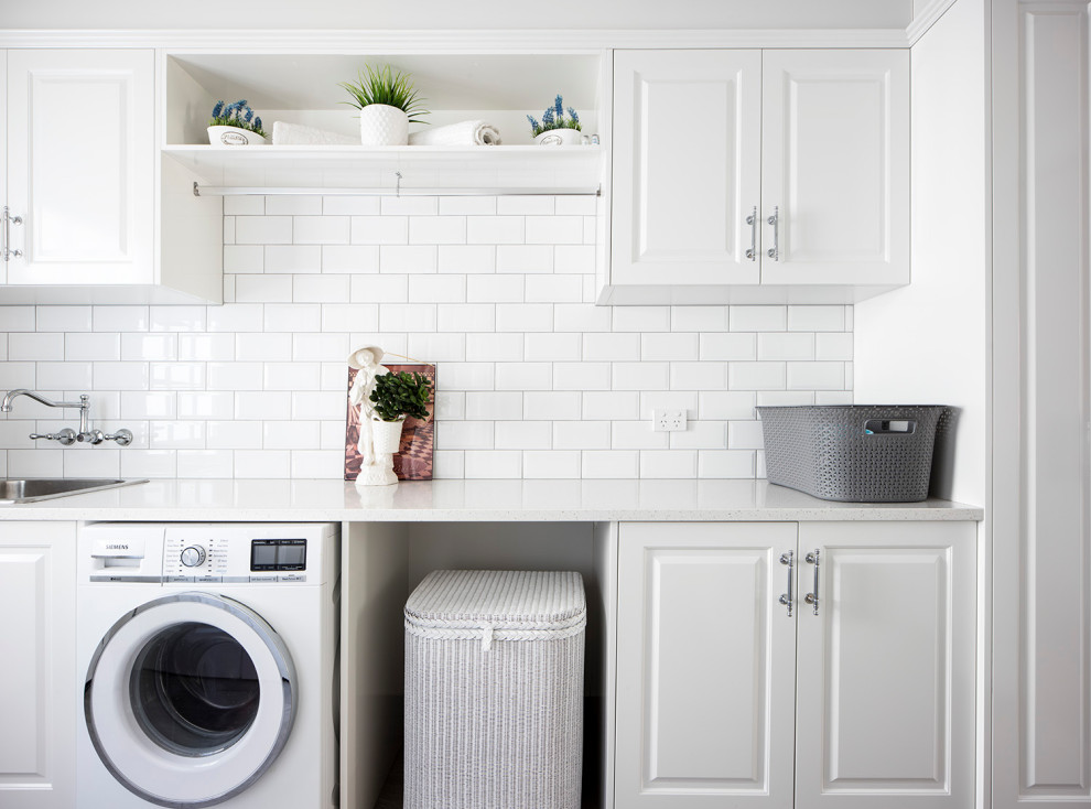 Mid-sized traditional single-wall dedicated laundry room in Brisbane with white cabinets, quartz benchtops, white walls, white benchtop, a drop-in sink and raised-panel cabinets.