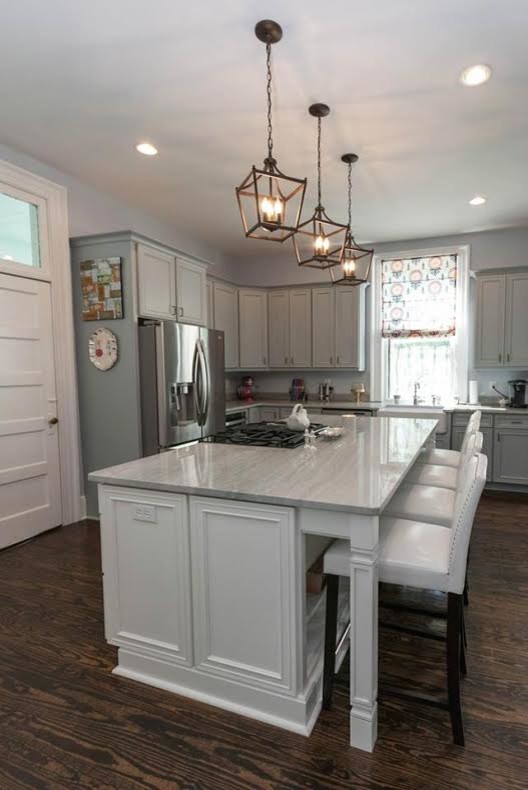 Photo of a mid-sized country l-shaped eat-in kitchen in Charleston with a farmhouse sink, recessed-panel cabinets, grey cabinets, granite benchtops, stainless steel appliances, medium hardwood floors and with island.