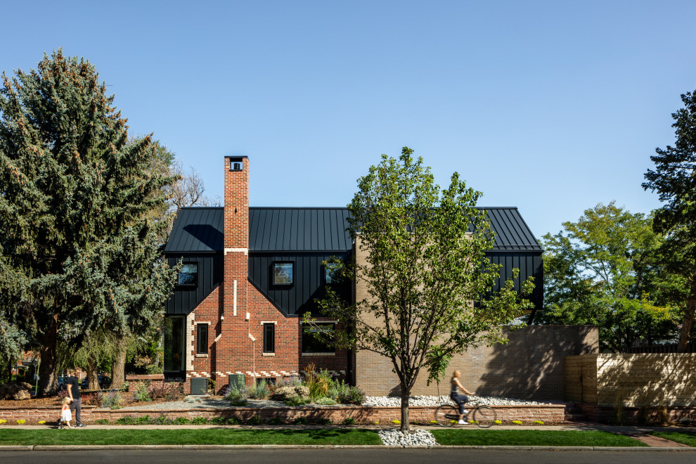 This is an example of a country black house exterior in Denver with a metal roof and a black roof.