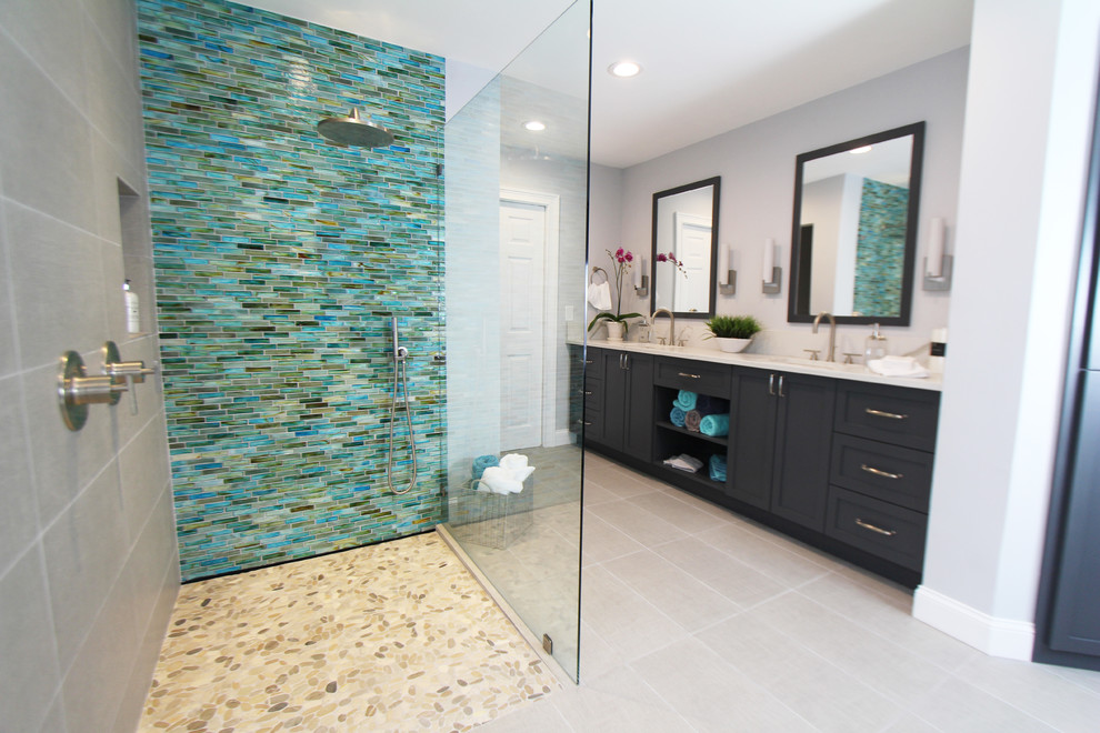 Large tropical master bathroom in Atlanta with shaker cabinets, grey cabinets, a freestanding tub, a curbless shower, a two-piece toilet, beige tile, porcelain tile, grey walls, porcelain floors, an undermount sink, engineered quartz benchtops, beige floor and an open shower.