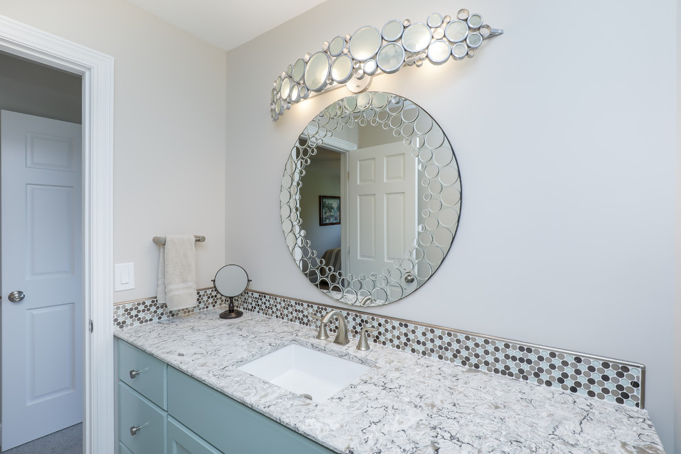 This is an example of a mid-sized transitional bathroom in Cleveland with recessed-panel cabinets, turquoise cabinets, a two-piece toilet, multi-coloured tile, mosaic tile, white walls, an undermount sink and quartzite benchtops.