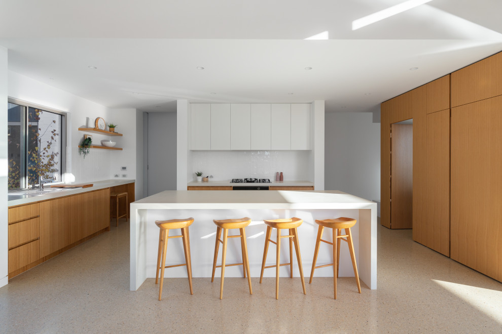 This is an example of a contemporary kitchen in Melbourne with light wood cabinets, concrete floors and with island.