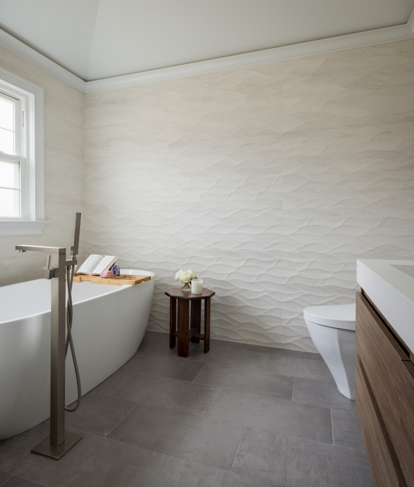 Inspiration för mellanstora moderna vitt en-suite badrum, med möbel-liknande, vita skåp, ett fristående badkar, en toalettstol med hel cisternkåpa, beige kakel, cementkakel, beige väggar, betonggolv, bänkskiva i akrylsten och grått golv